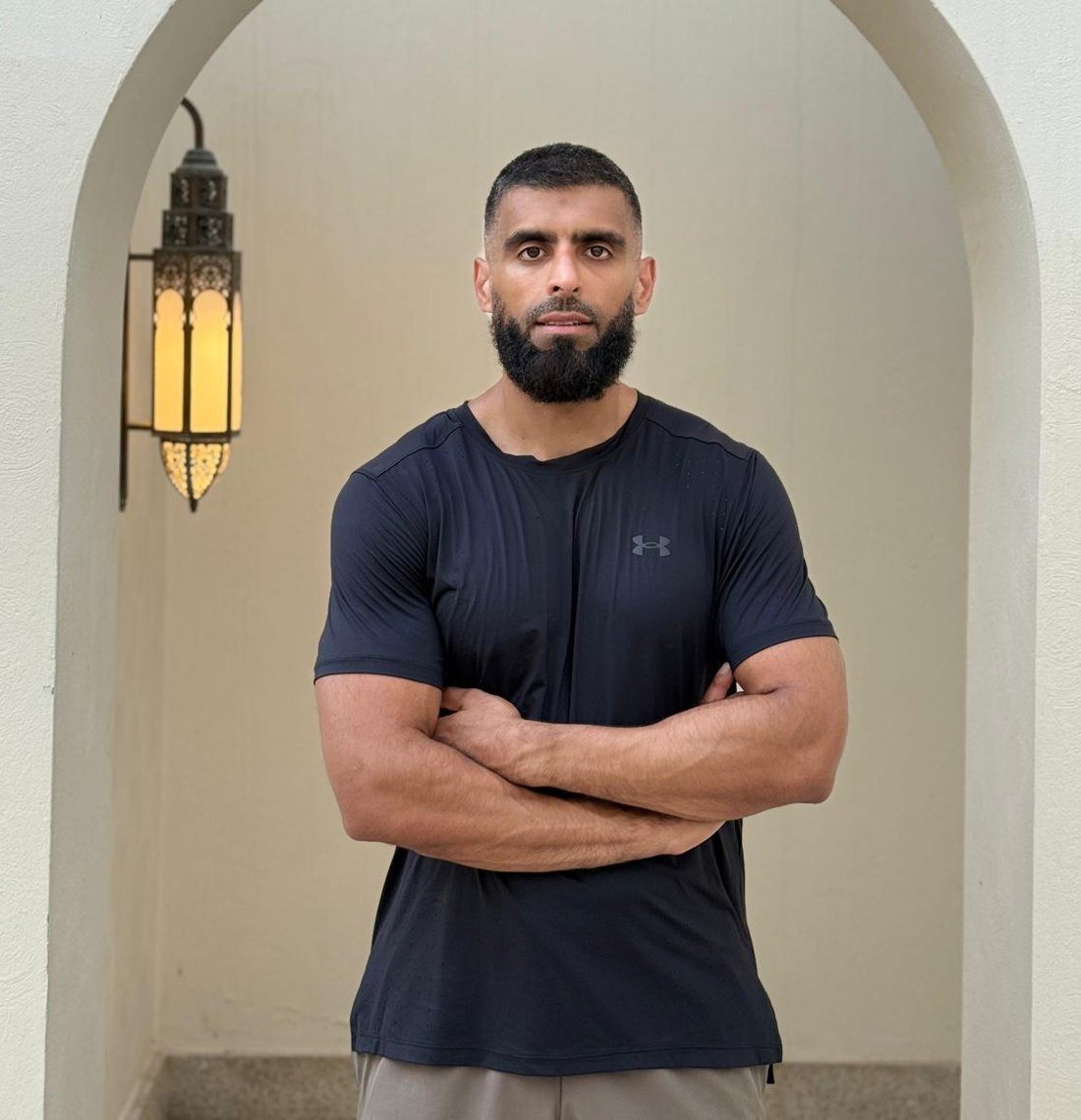 Mohammed, online fitness coach for busy Muslim men, standing in an archway